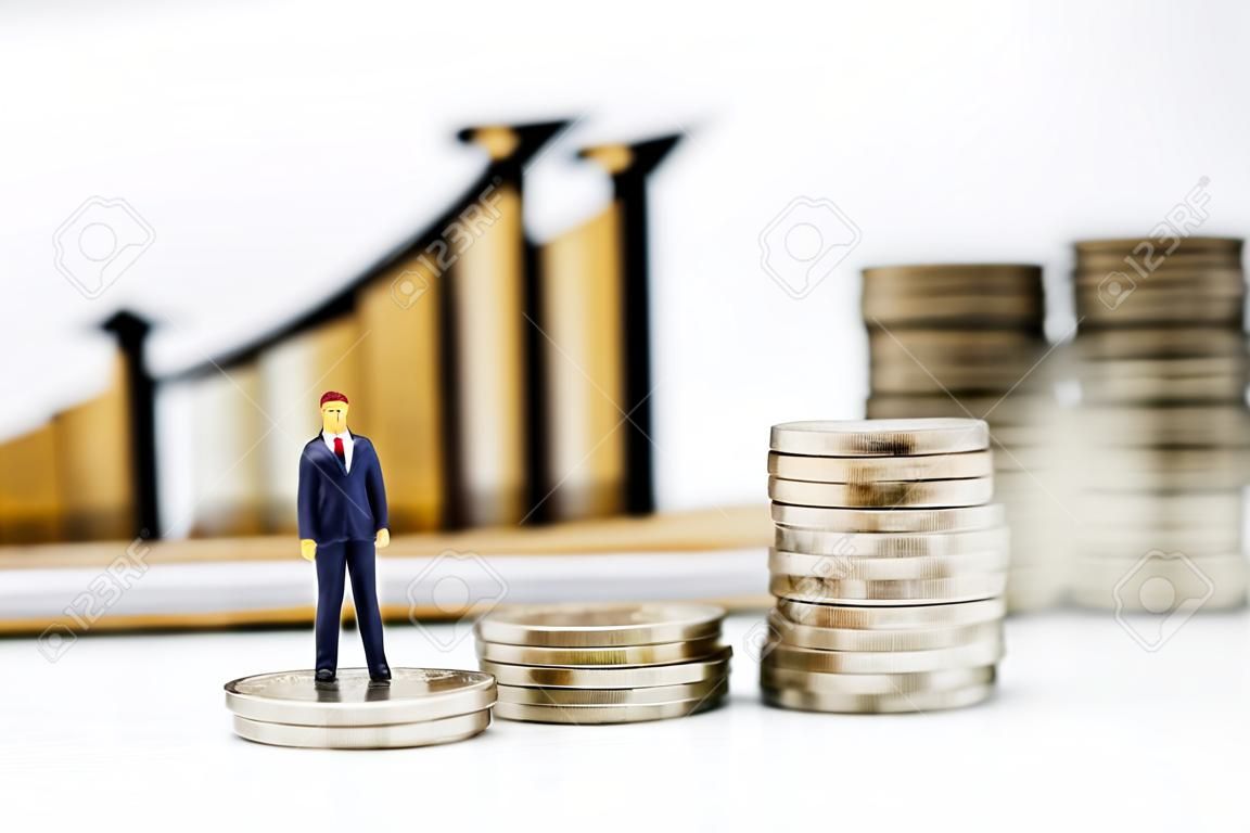 Personnes miniatures : hommes d'affaires debout sur une pile de pièces avec graphique, finances, investissement et croissance du concept d'entreprise.