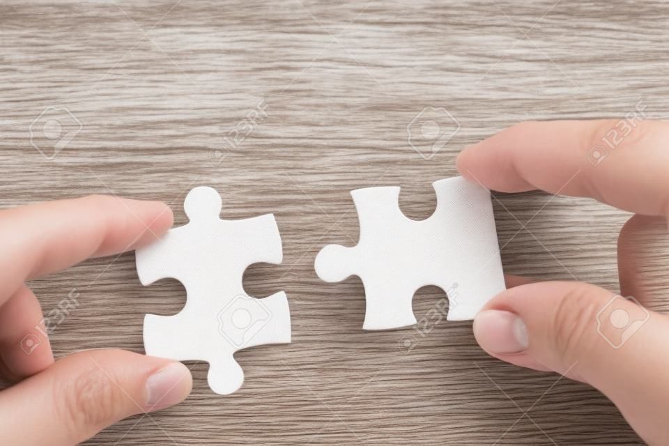 two hands person trying to connect couple Jigsaw paper white puzzle piece with tree fresh background. one part of whole. symbol of association and connection. success and business solution strategy.