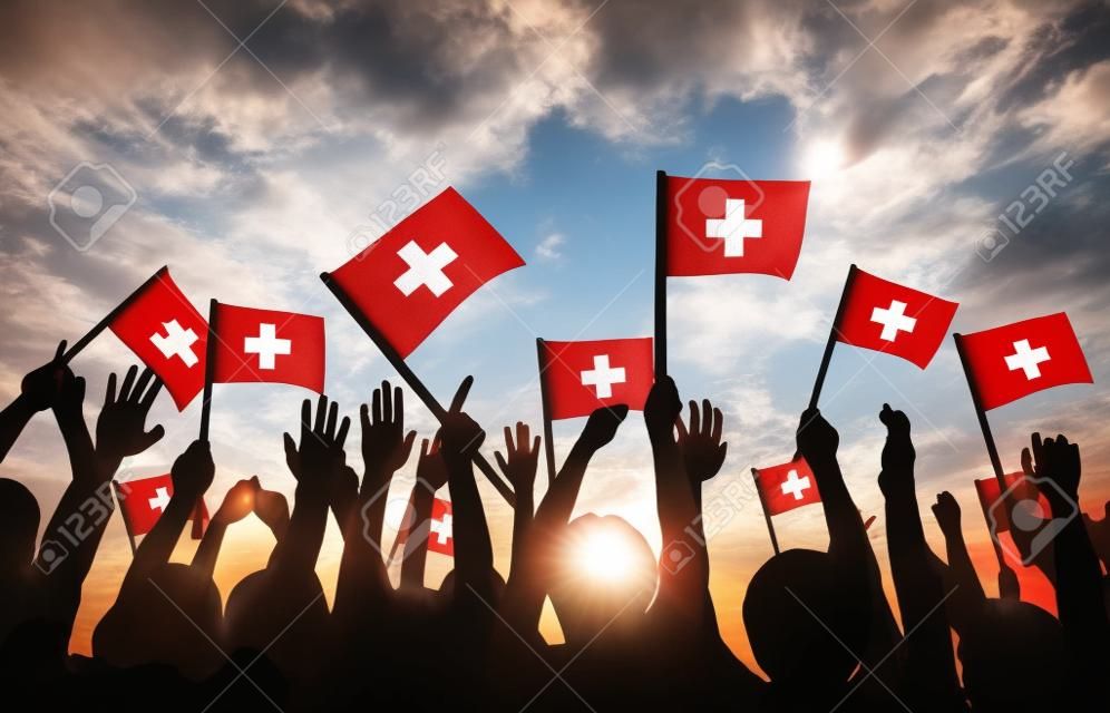 Gruppe von Personen, Winken Schweiz Flags in Gegenlicht