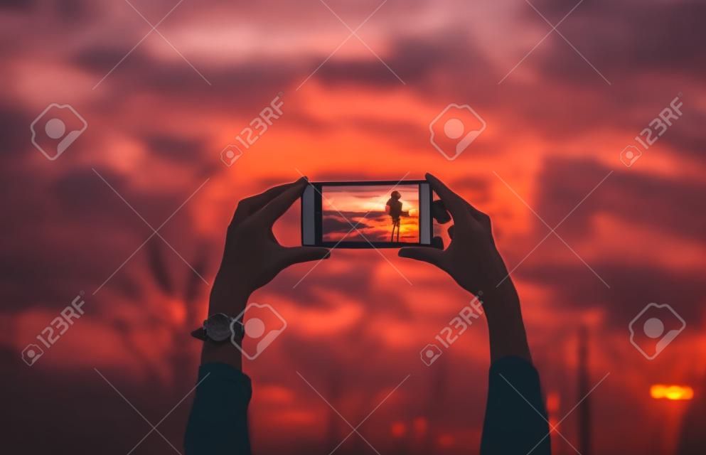 Woman taking a photo of the sunset