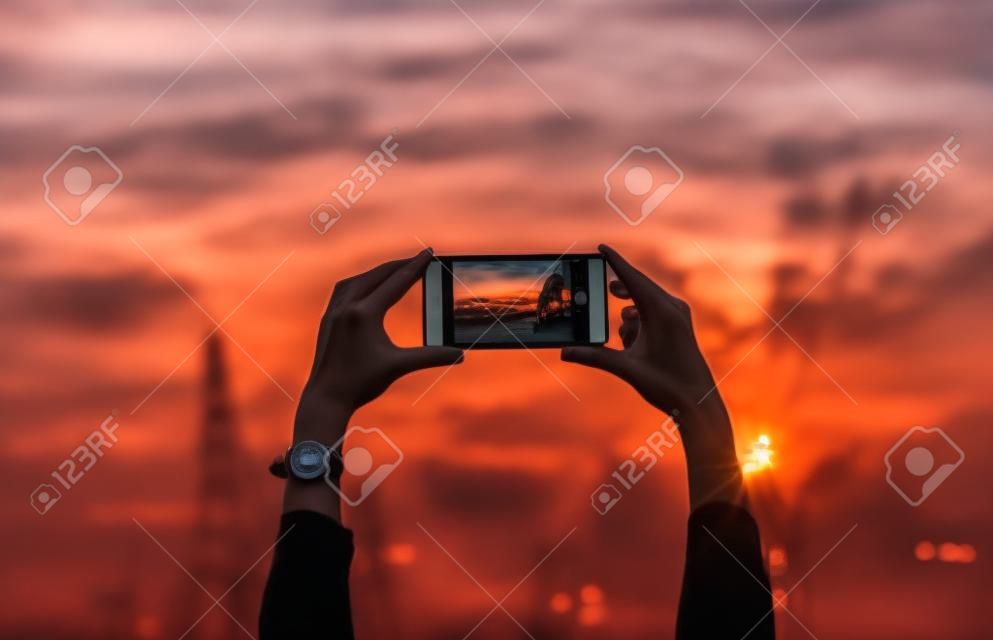 Woman taking a photo of the sunset