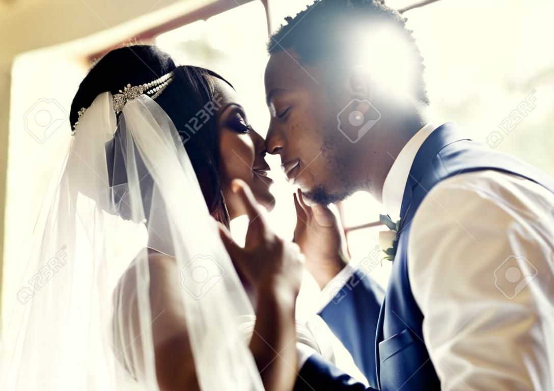Nowożeńcy pan młody pochodzenia afrykańskiego otwierają wesele z welonem panny młodej