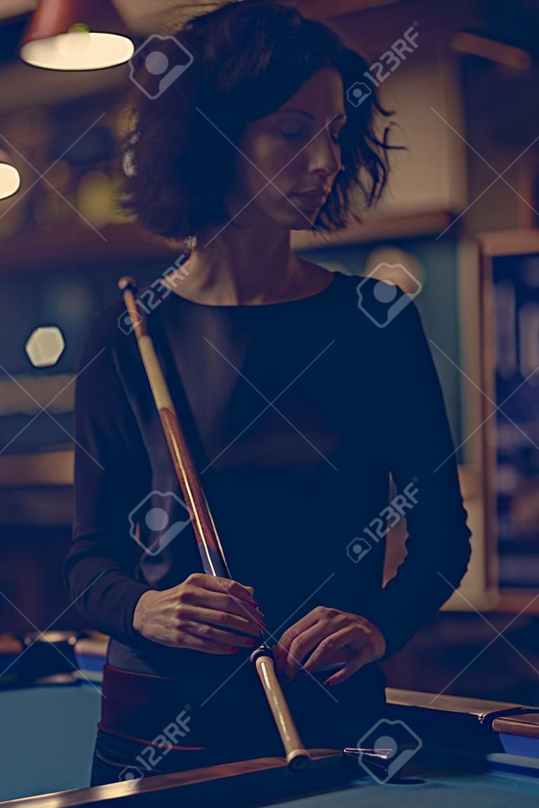 Mujer jugando al billar en un bar