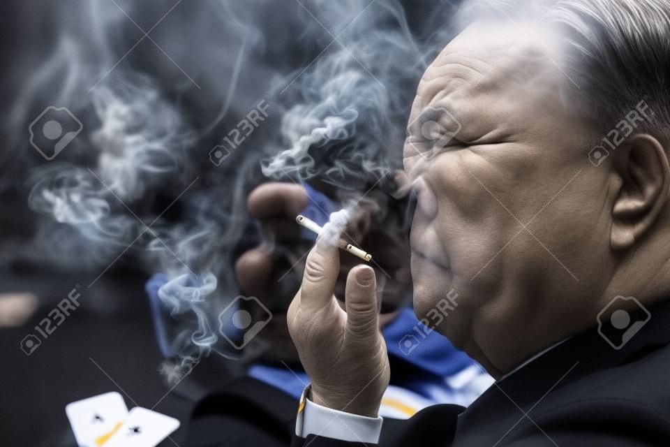 A man smoking in a gambling circle
