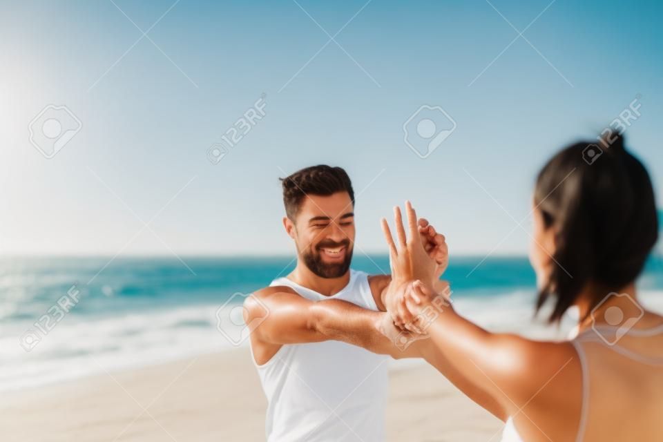 Paare, die am Strand ausdehnen