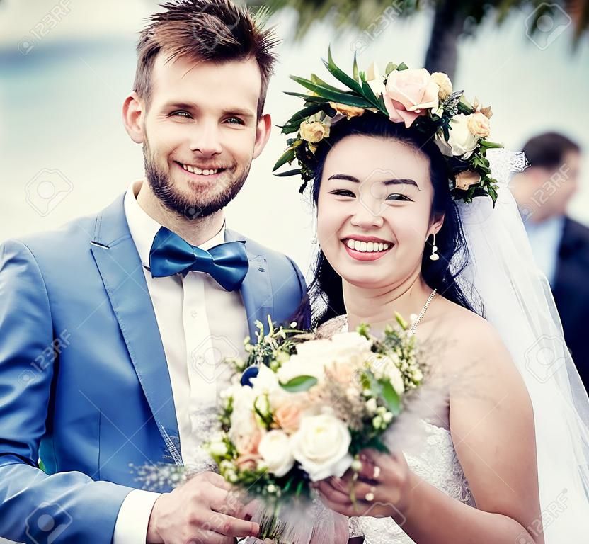 Jeunes mariés gais à la cérémonie de mariage de plage