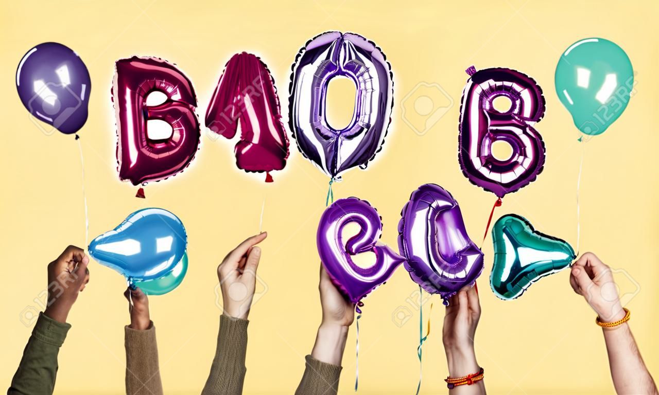 Mãos que mostram a palavra dos balões do bebê