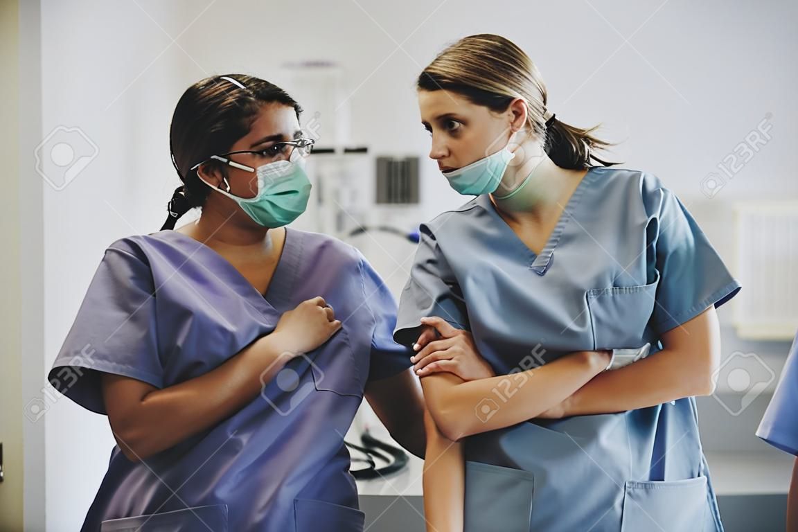 Verpleegsters die een gesprek hebben op de ICU