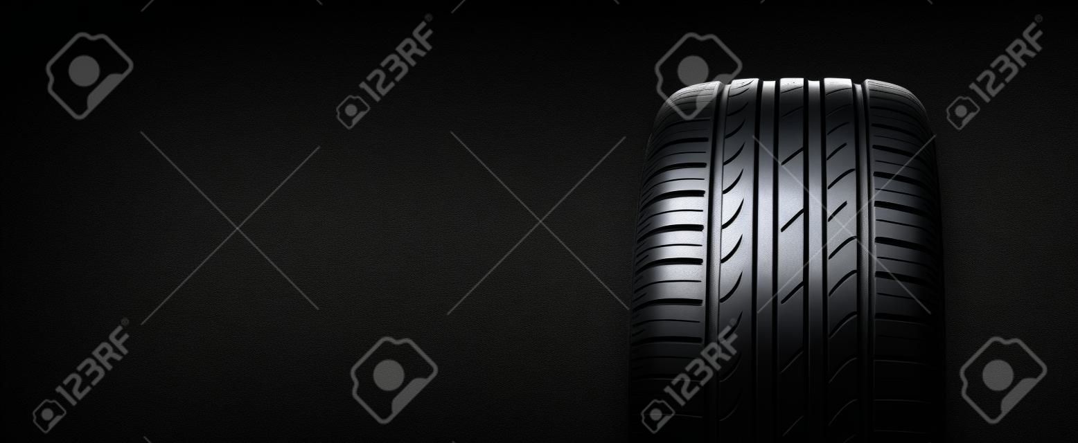 pneu de verão em um fundo preto. espaço para texto, cópia espaço panorama