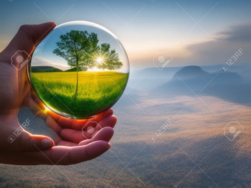 Splendido paesaggio del Parco Nazionale della Sassonia in Germania che si riflette in una grande palla di vetro nelle dita della mano maschile