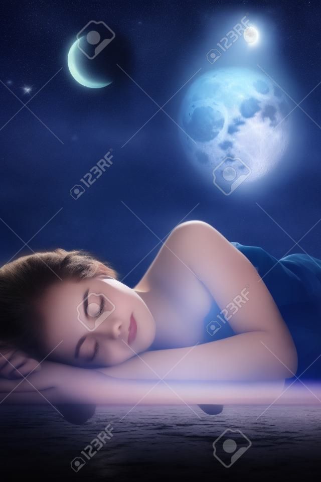 Girl sleeping at night on background of the moon