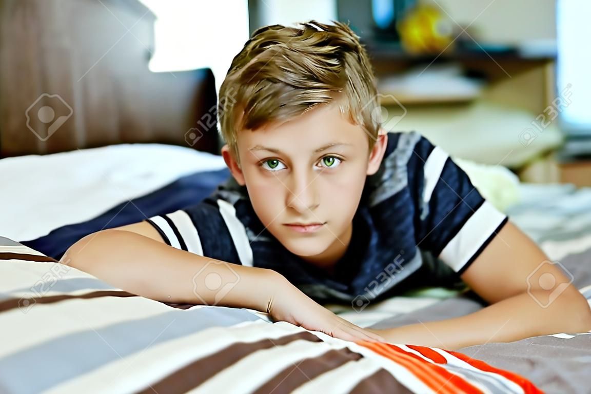 teen boy at home laying on the bed 