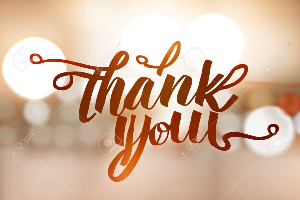 A thank you, lettering on golden blurred background of lights