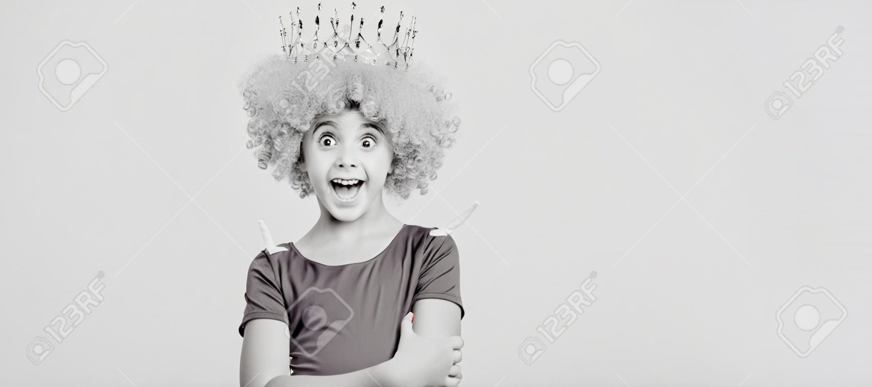 happy selfish child girl in curly wig and princess diadem, happiness. Funny teenager child in wig, party poster. Banner header, copy space.