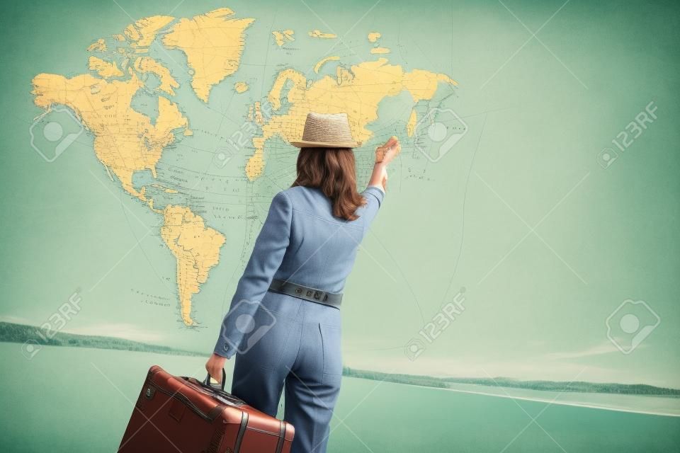 ヴィンテージ スーツケースと旅行者の女性は、世界の地図に手を振り。旅行のコンセプト