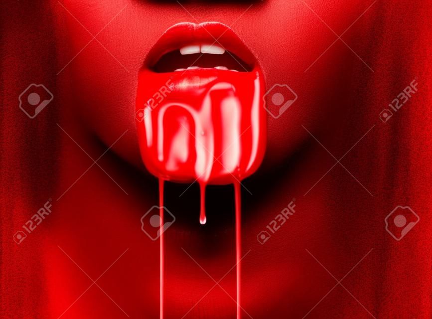 Il sangue scorre dalla bocca di una donna. Primo piano l'immagine di labbra rosse. Halloween o di orrore tema