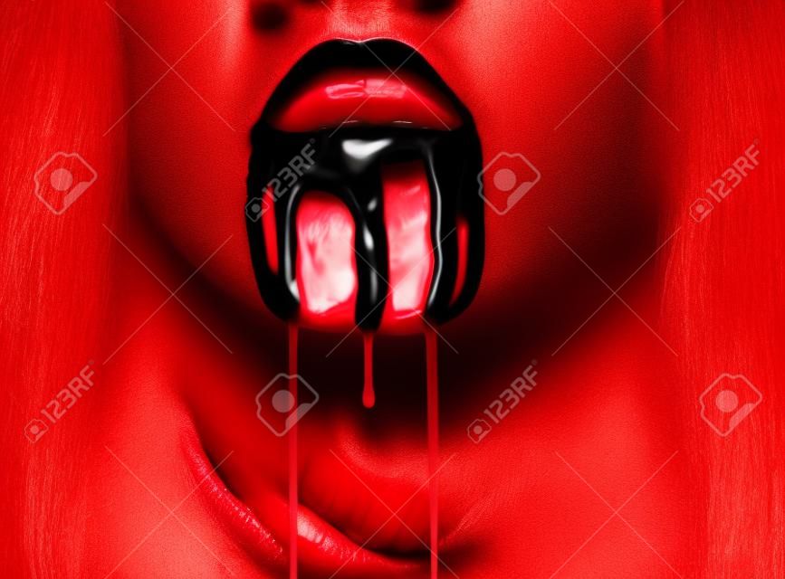 Il sangue scorre dalla bocca di una donna. Primo piano l'immagine di labbra rosse. Halloween o di orrore tema