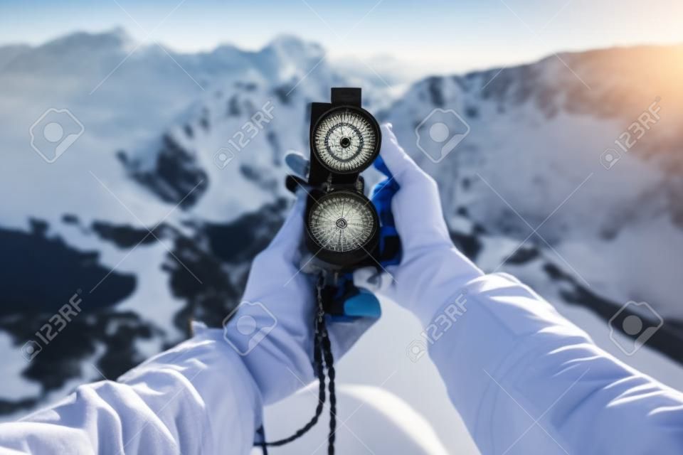 Female traveler searching direction with a compass in the mountains. Point of view shot