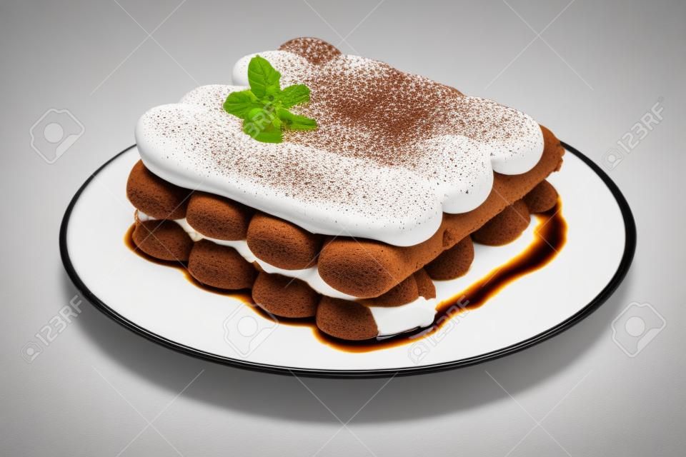 Klasyczny deser tiramisu na talerzu ceramicznym na białym tle ze ścieżką przycinającą