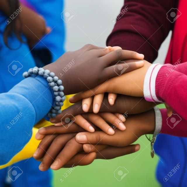 Группа подростков штабелирования свои руки, единство и солидарность