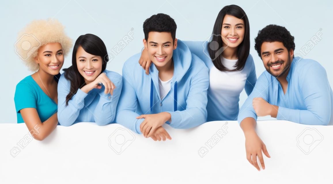Feliz grupo multiétnico de amigos que muestra la cartelera en blanco aislado en fondo blanco