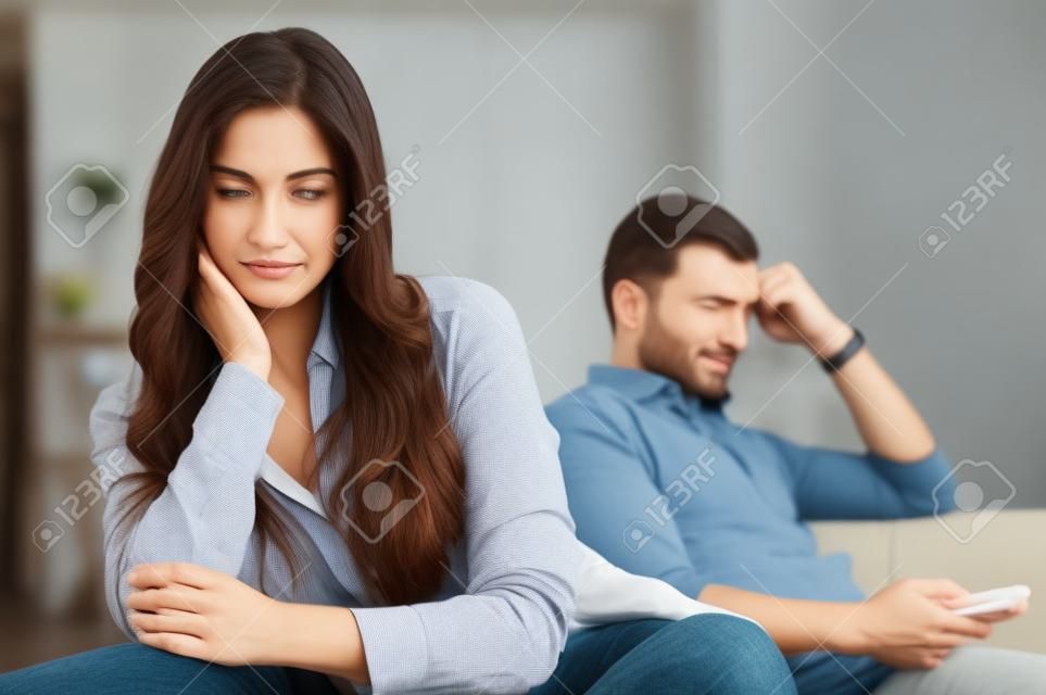 Couple triste assis sur un canapé après s'être disputé