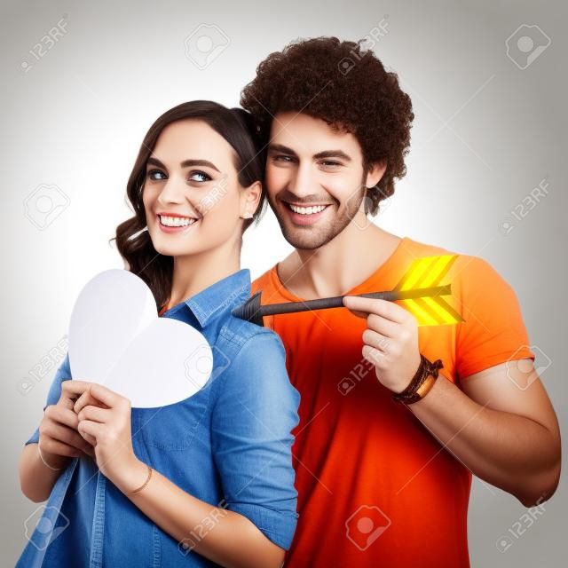 快乐的夫妇抱着箭与纸心孤立的白色背景