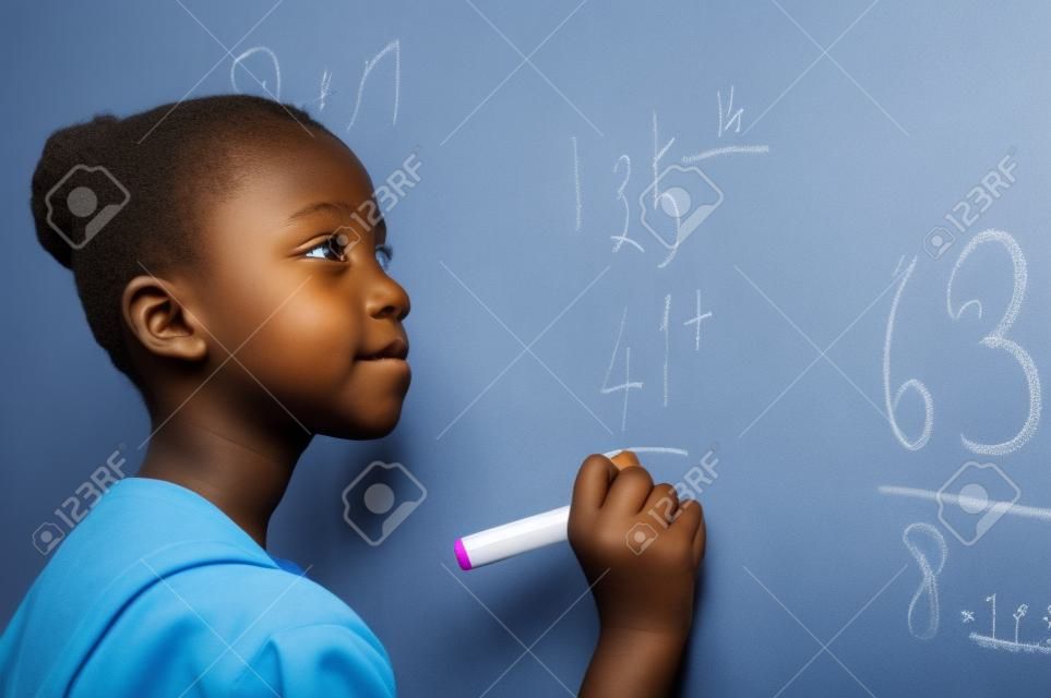 Porträt des afrikanischen Mädchens, das Lösung der Summen auf der weißen Tafel in der Schule schreibt. Schwarzes Schulmädchen, das Zusatzsumme auf weißer Tafel mit Markierungsstift löst. Schulkind denkt, während es Mathematikproblem macht.