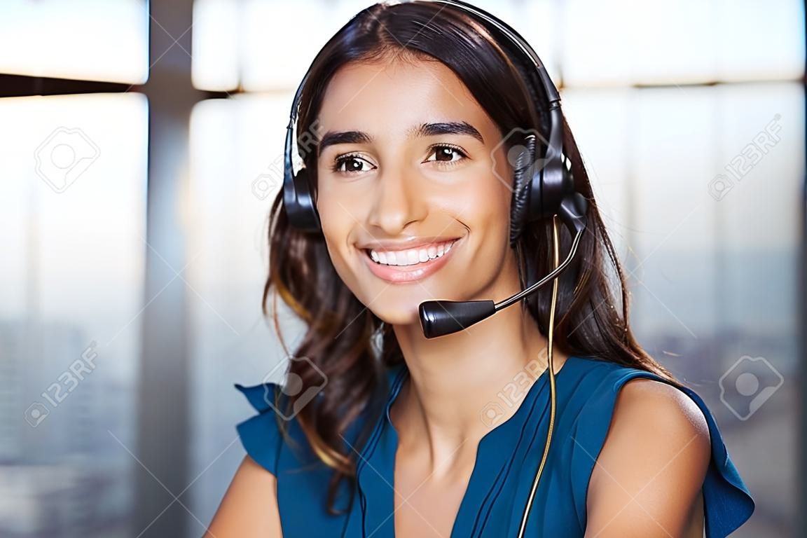 Customer support vrouw glimlachen en kijken naar camera. Portret van gelukkige klantenservice telefoon operator bij call center dragen headset. Vrolijke executive tot uw dienst werken op kantoor.