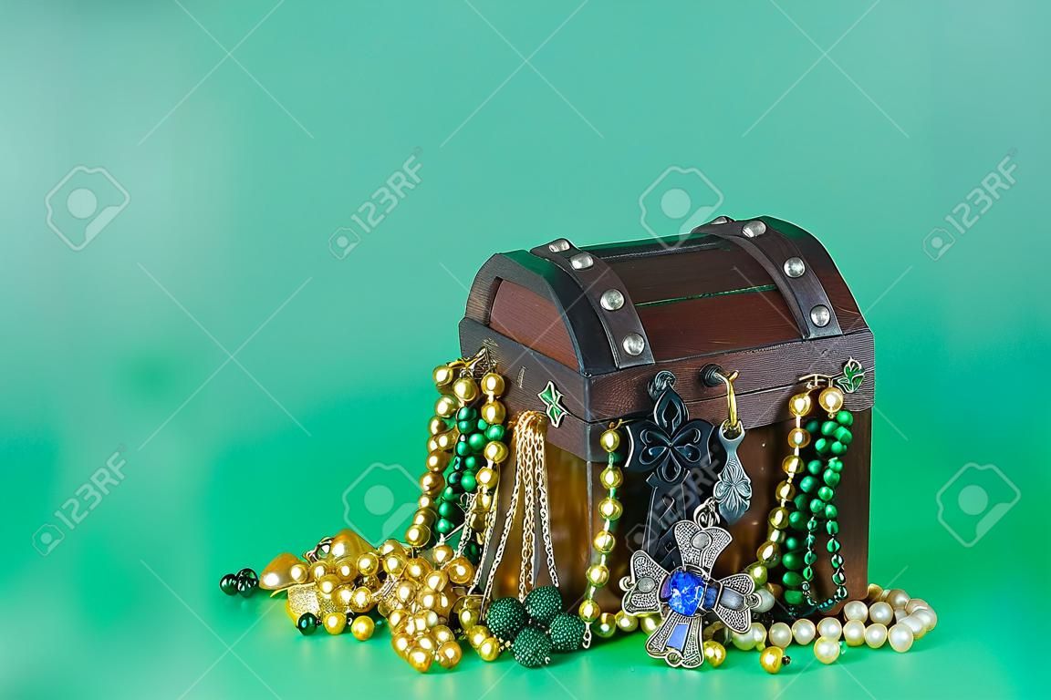 Bild für den Saint Patricks Day am 17. März. Schatztruhe als Symbol für Glück und Reichtum ist mit Modeschmuck und Perlen gefüllt. Platz kopieren