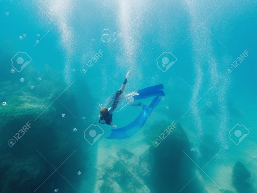 A young woman free diving in the bubbles