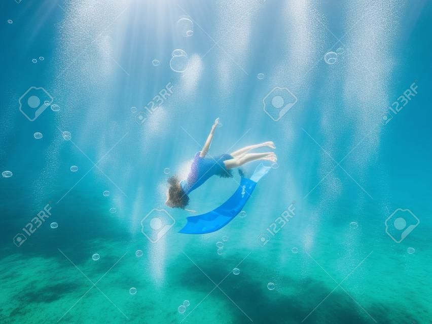 A young woman free diving in the bubbles