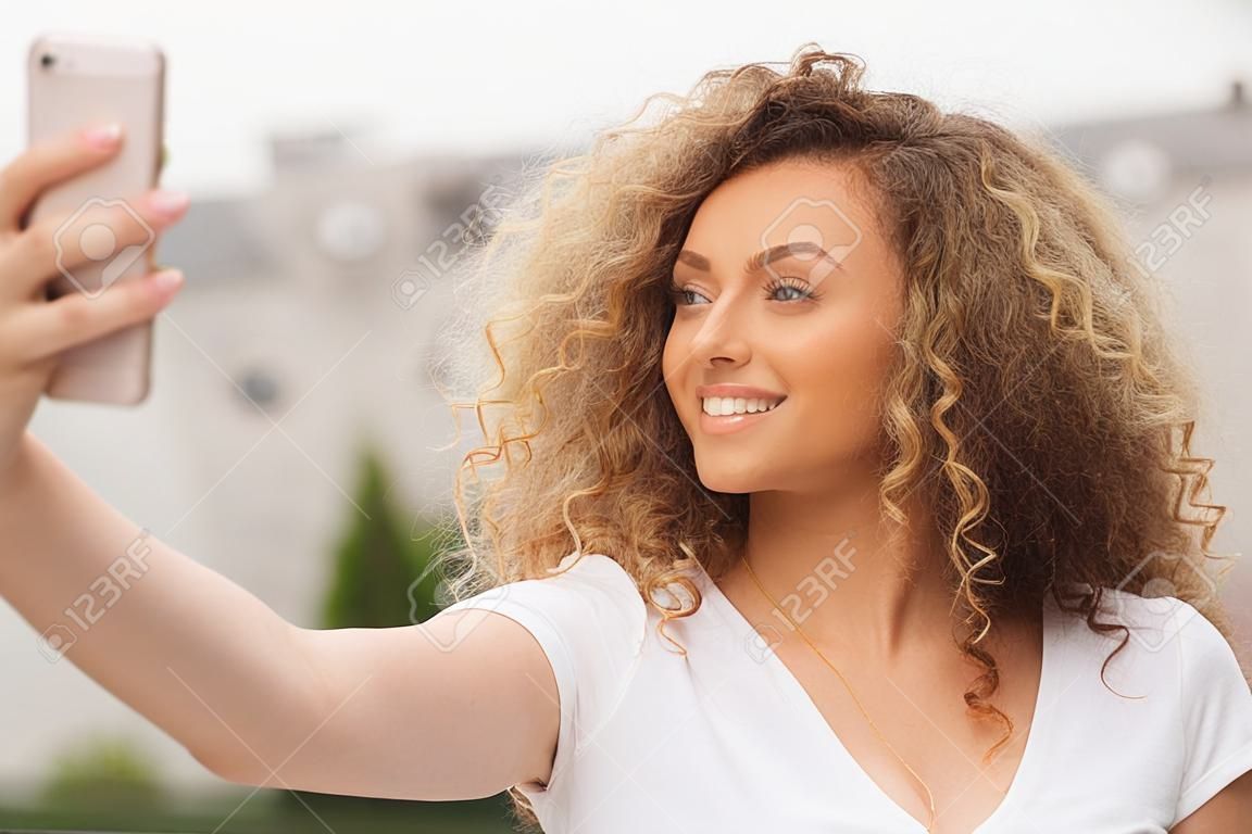Beautiful curly hair girl taking selfie
