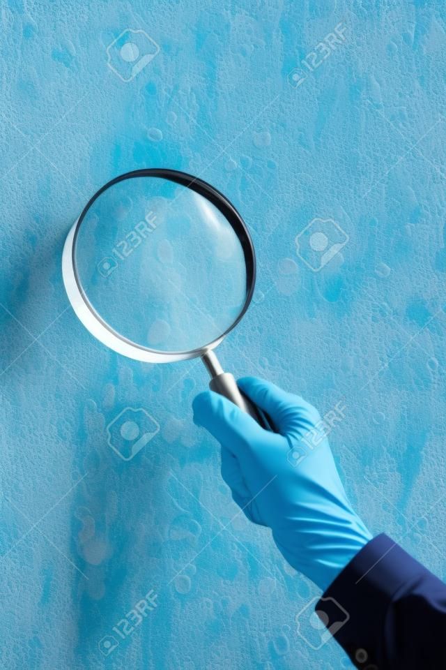 Um homem com lupa verificação de vidro fungo mofo