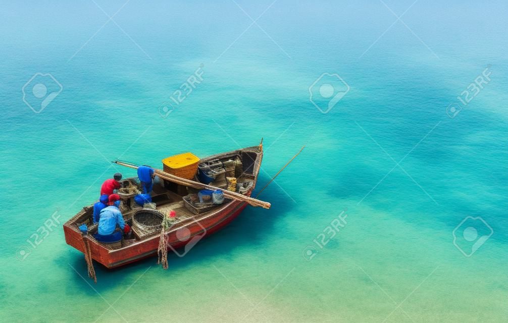Vista aérea, barco de pesca com pescadores artesanais perto da costa