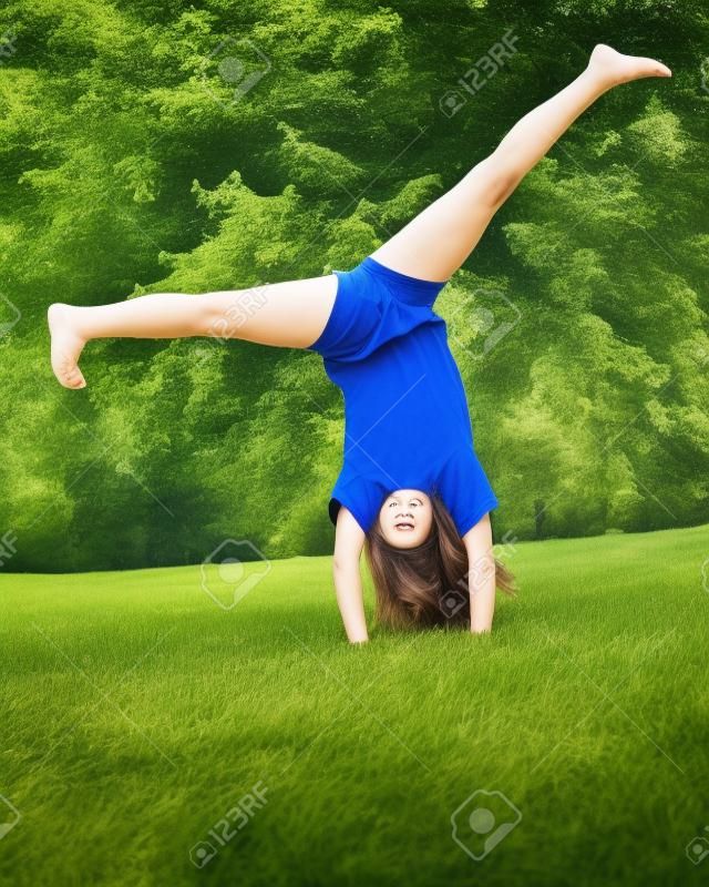 MÅ‚oda dziewczyna robi Cartwheel na Å›wieÅ¼ym powietrzu w parku
