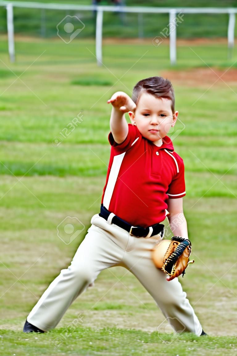 Child in uniform throwing baseball during game
