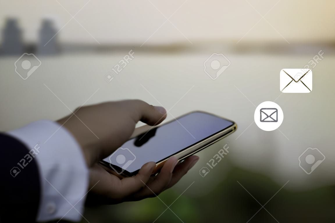 저희에게 연락하거나 고객 지원 핫라인 사람들이 연결합니다. (이메일, 전화, 메일) 아이콘이 있는 휴대전화를 사용하는 사업가입니다.