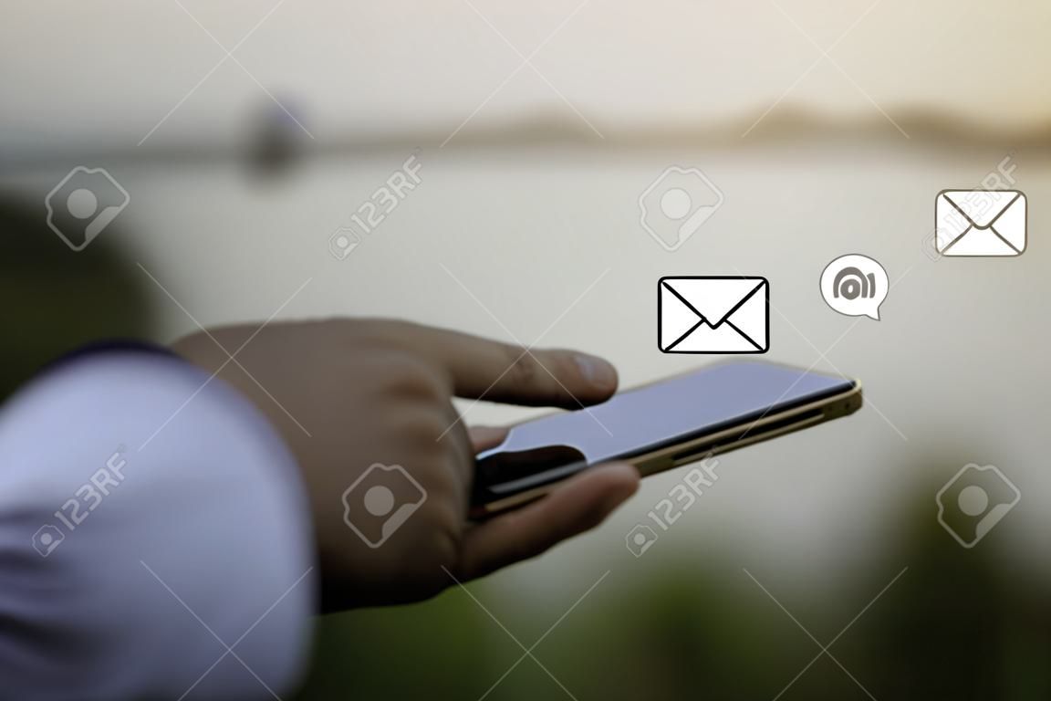 Kontaktieren Sie uns oder die Mitarbeiter der Kundensupport-Hotline. Geschäftsmann, der ein Mobiltelefon mit den Symbolen (E-Mail, Telefon, Post) verwendet.