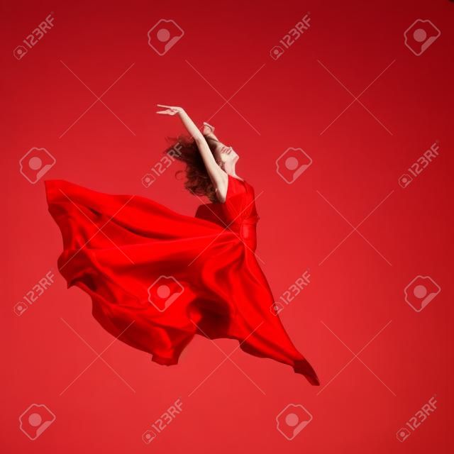 Donna in aria abito rosso che salta in aria