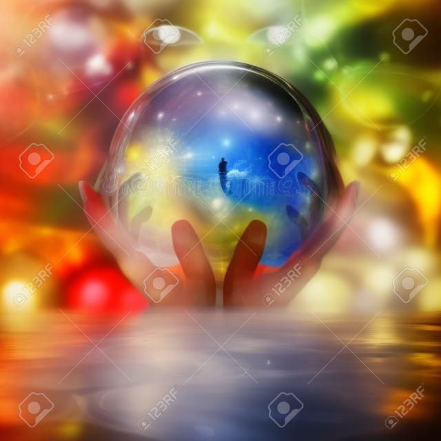 стеклянный шар в руках с абстрактным фоном