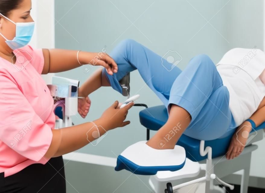 Woman in gynecological chair during gynecological check up with her doctor. Gynecologist examines a woman. Diagnostic, healthcare, medical service