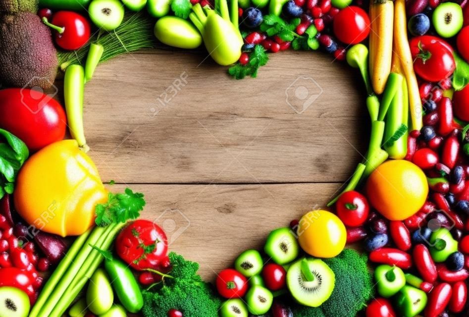 A forma di cuore cibo - cibo fotografia del cuore da diversi frutti e verdure su tavola di legno