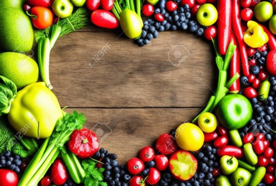 심장 모양의 음식 - 나무 테이블에 다른 과일과 야채로 만든 심장의 음식 사진