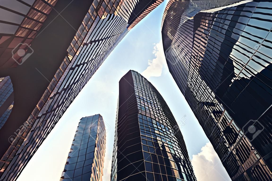 Low angle view of skyscrapers. Skyscrapers at sunset looking up perspective. Bottom view of modern skyscrapers in business district in evening light at sunset. Business concept of success industry tech architecture, 3D rendering