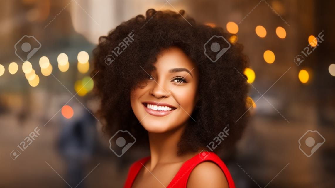 Hermosa mujer afroamericana con cabello rizado en la ciudad