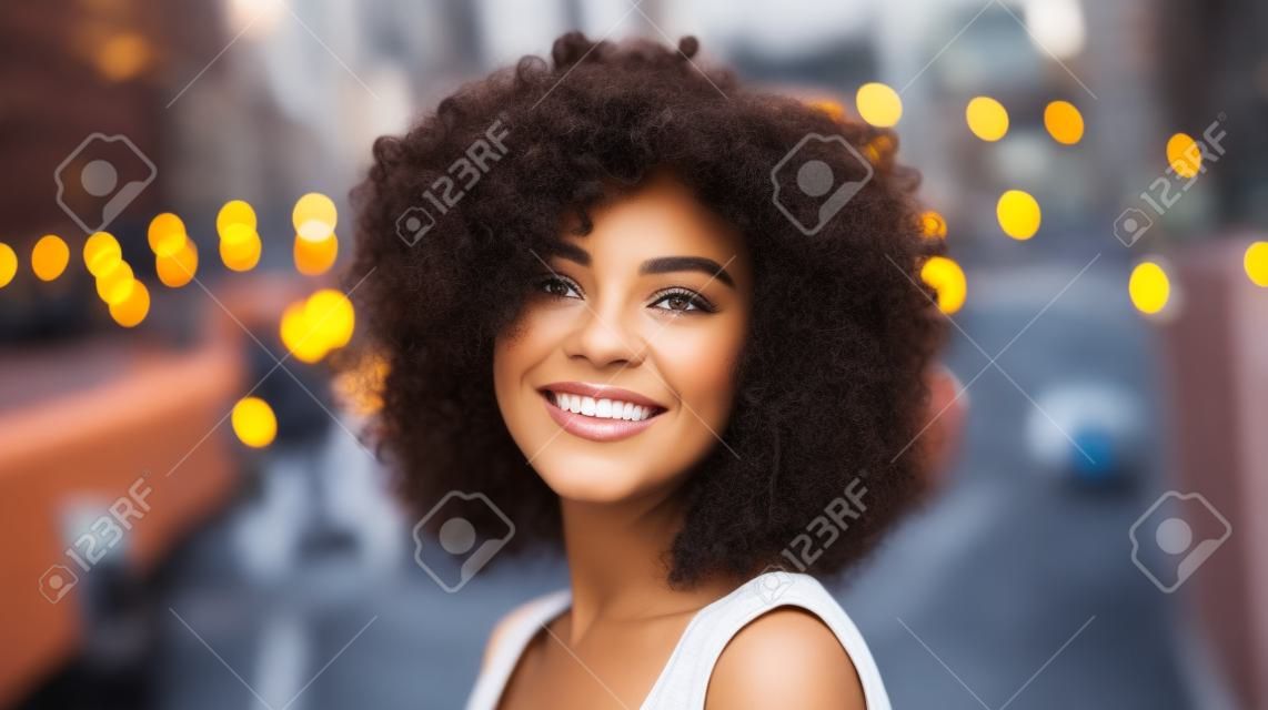 Hermosa mujer afroamericana con cabello rizado en la ciudad