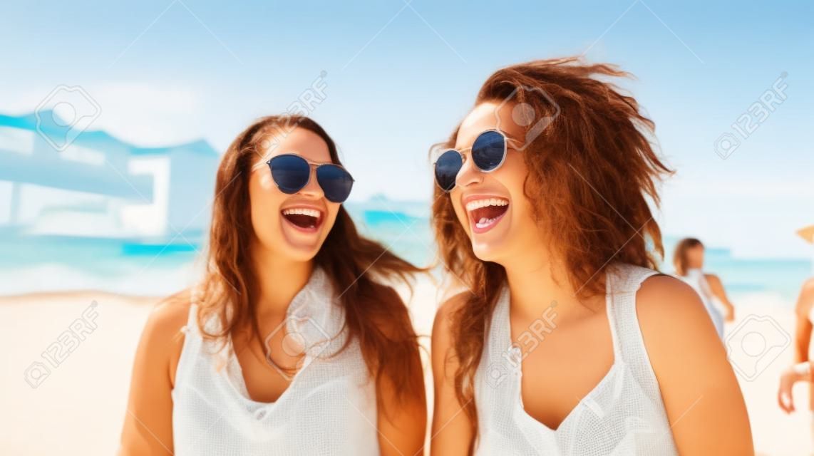 Retrato de duas jovens felizes se divertindo na praia.