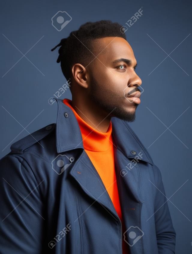 Handsome african american man in orange jacket on blue background