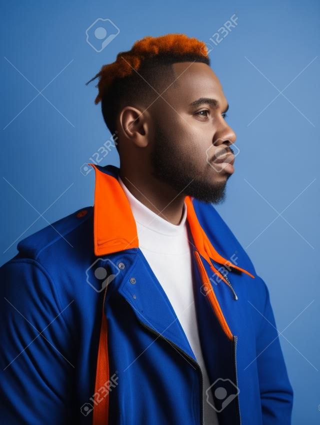 Handsome african american man in orange jacket on blue background